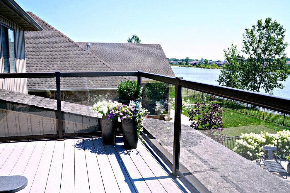 Example of a large transitional two-story and backyard vinyl beige deck design in Toronto with a hip roof and no cover