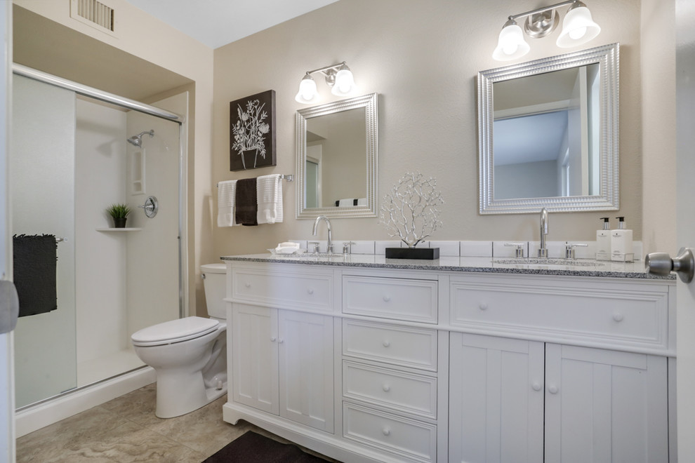 Example of a mid-sized transitional 3/4 porcelain tile and beige floor alcove shower design in Phoenix with furniture-like cabinets, white cabinets, a two-piece toilet, gray walls, an undermount sink, granite countertops and gray countertops
