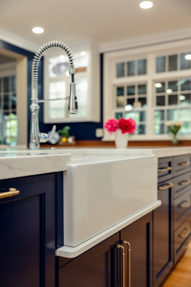 Inspiration for a huge transitional u-shaped brown floor kitchen remodel with a farmhouse sink, shaker cabinets, quartz countertops, white backsplash, quartz backsplash, stainless steel appliances, two islands and white countertops