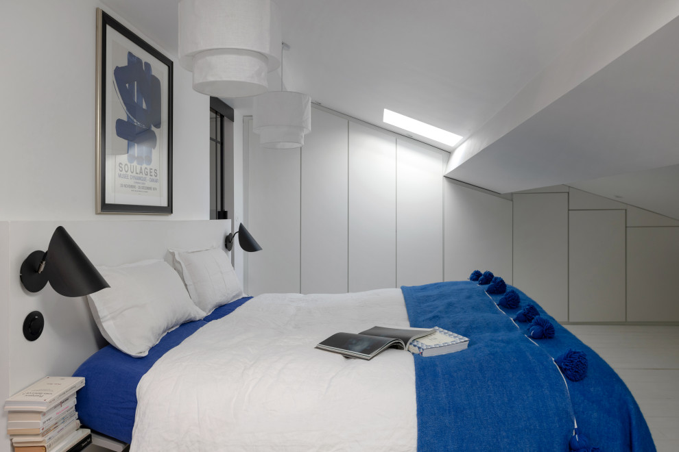 Immagine di una piccola camera da letto stile loft minimalista con pareti bianche, pavimento in legno verniciato, nessun camino e pavimento bianco