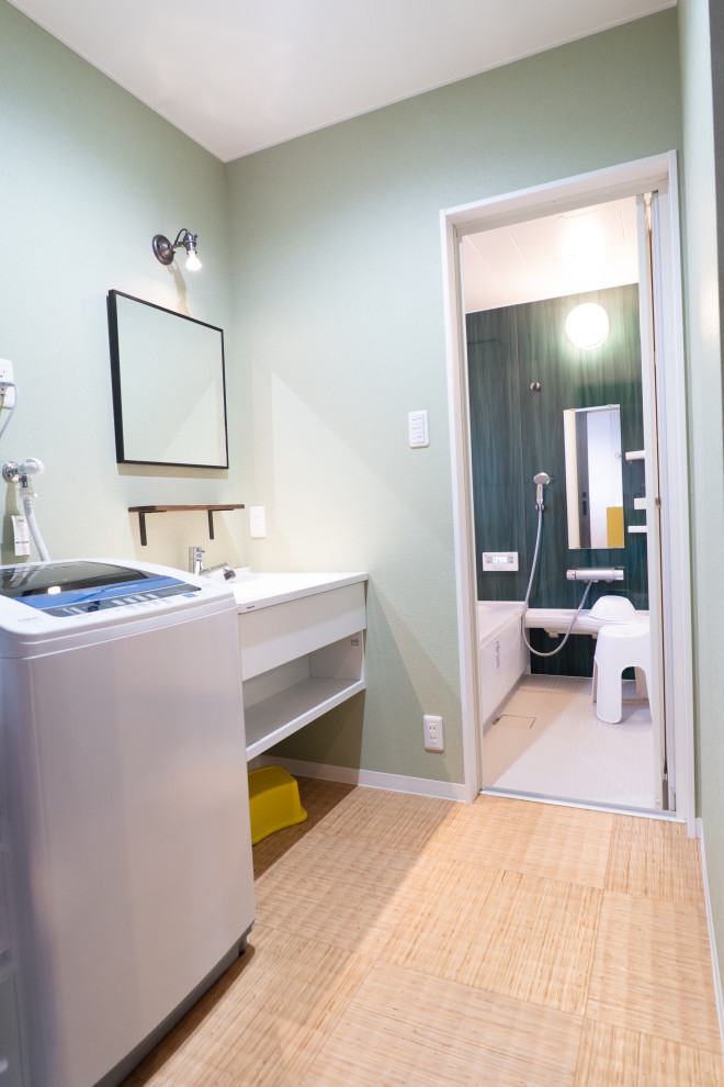 This is an example of a small asian powder room in Other with open cabinets, white cabinets, green walls, vinyl floors, beige floor, white benchtops and an integrated sink.
