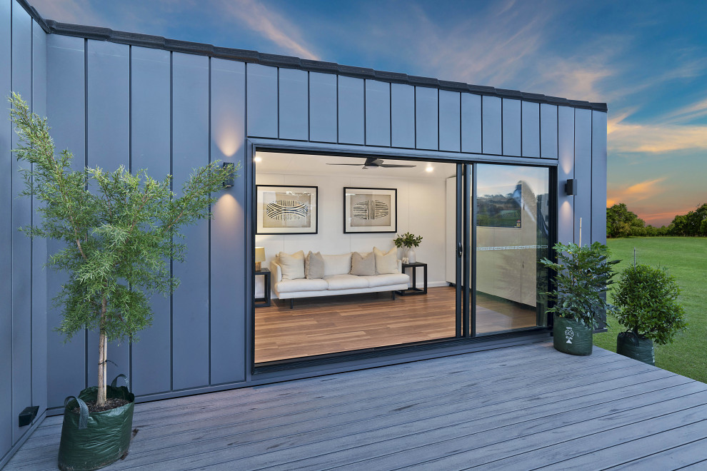 This is an example of a mid-sized living room in Brisbane with white walls, vinyl floors, a built-in media wall, brown floor, vaulted and panelled walls.