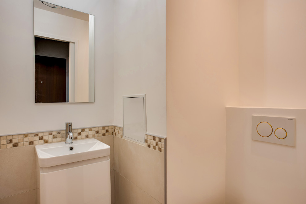 Photo of a contemporary powder room in Paris with a wall-mount toilet, beige tile, ceramic tile, beige walls, mosaic tile floors, a vessel sink and beige floor.