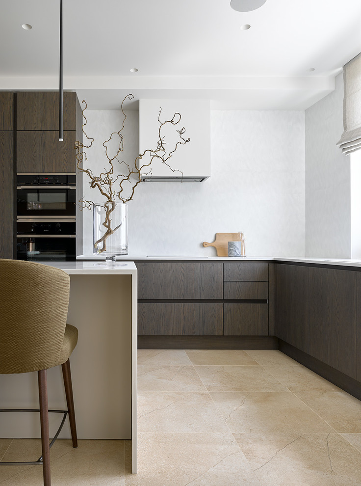 Inspiration for a contemporary open plan kitchen in Moscow with flat-panel cabinets, dark wood cabinets, white splashback, stainless steel appliances, with island, beige floor and white benchtop.