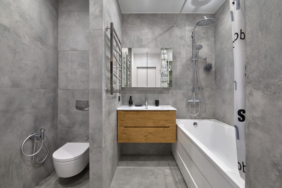 This is an example of a mid-sized industrial bathroom in Moscow with flat-panel cabinets, medium wood cabinets, gray tile, porcelain tile, grey walls, porcelain floors, an integrated sink, grey floor and a floating vanity.