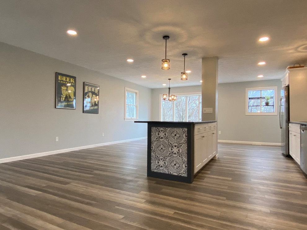 Large transitional l-shaped vinyl floor and gray floor open concept kitchen photo in Cincinnati with an undermount sink, raised-panel cabinets, white cabinets, granite countertops, multicolored backsplash, ceramic backsplash, stainless steel appliances, an island and black countertops