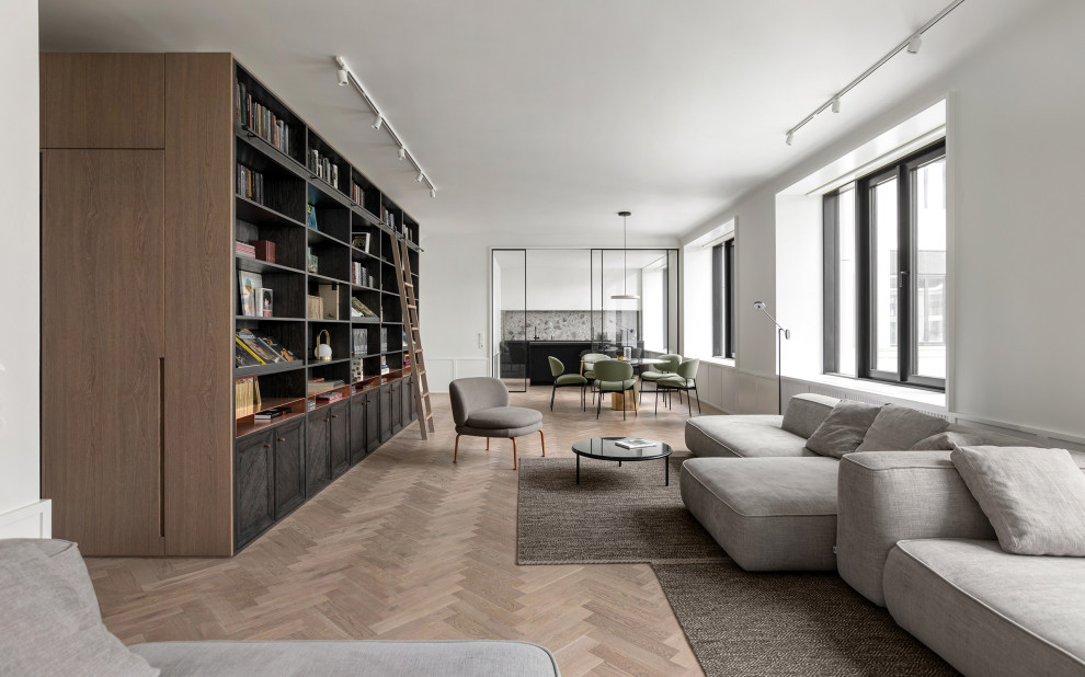 Ejemplo de biblioteca en casa abierta y blanca y madera actual de tamaño medio con paredes blancas, suelo de madera en tonos medios, televisor independiente y panelado