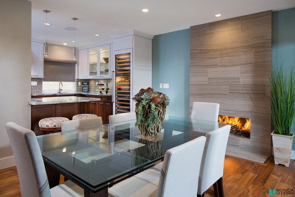 Photo of a transitional open plan dining in Orange County with blue walls, medium hardwood floors, a ribbon fireplace and a tile fireplace surround.