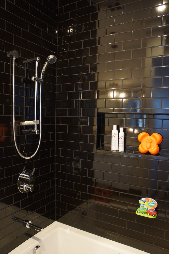 This is an example of a contemporary bathroom in Chicago with a shower/bathtub combo, black tile and subway tile.