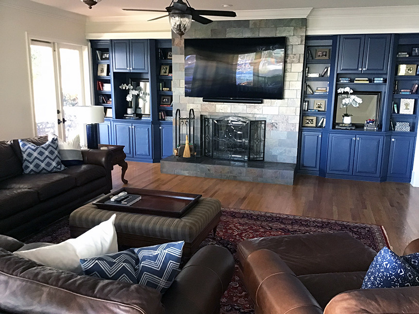 This is an example of a large traditional open plan games room in Orlando with white walls, medium hardwood flooring, a standard fireplace, a tiled fireplace surround, a wall mounted tv and brown floors.