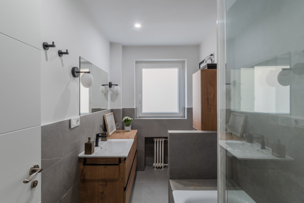 Diseño de aseo de pie actual de tamaño medio con armarios tipo mueble, puertas de armario blancas, sanitario de dos piezas, baldosas y/o azulejos grises, baldosas y/o azulejos de cerámica, paredes grises, suelo de baldosas de porcelana, lavabo encastrado, encimera de madera, suelo gris, encimeras marrones y panelado