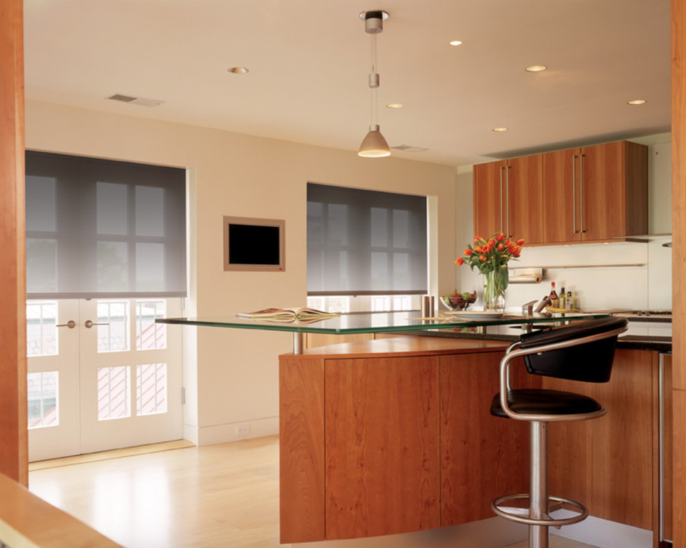 Large trendy l-shaped light wood floor and brown floor eat-in kitchen photo in San Diego with an undermount sink, flat-panel cabinets, dark wood cabinets, glass countertops, white backsplash, porcelain backsplash, stainless steel appliances and an island