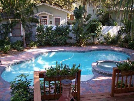 Small transitional backyard concrete paver and custom-shaped hot tub photo in Tampa
