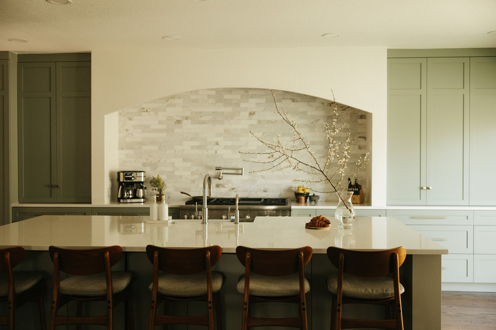 Transitional l-shaped dark wood floor and brown floor eat-in kitchen photo in Portland with a farmhouse sink, shaker cabinets, green cabinets, quartz countertops, multicolored backsplash, marble backsplash, stainless steel appliances, an island and white countertops