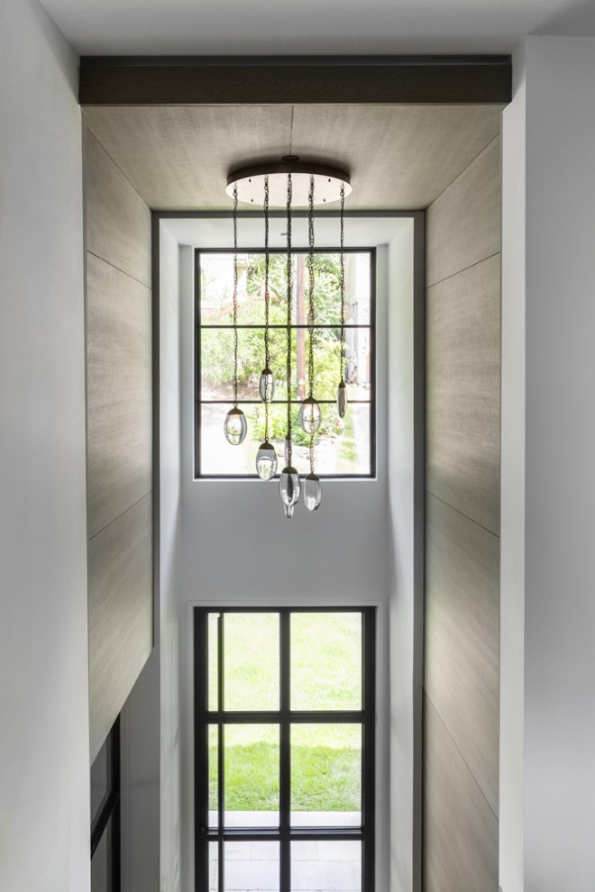 オースティンにある中くらいなトランジショナルスタイルのおしゃれな玄関ロビー (白い壁、ライムストーンの床、ガラスドア、ベージュの床、板張り天井、板張り壁、グレーの天井) の写真