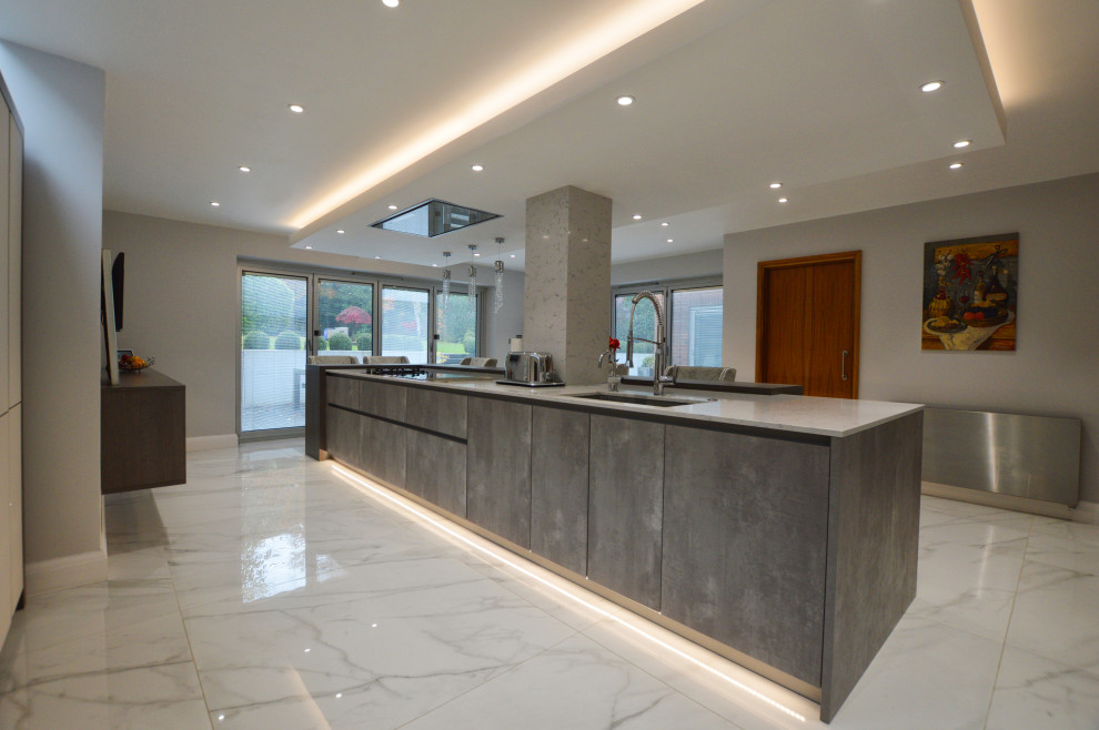 Inspiration for an expansive modern single-wall eat-in kitchen in Buckinghamshire with a drop-in sink, flat-panel cabinets, quartzite benchtops, stainless steel appliances, with island and white benchtop.