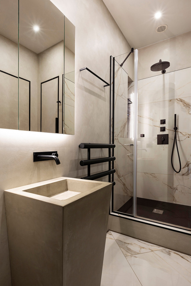This is an example of a mid-sized contemporary 3/4 bathroom in Saint Petersburg with beaded inset cabinets, beige cabinets, an alcove shower, a wall-mount toilet, beige tile, marble, grey walls, porcelain floors, an integrated sink, concrete benchtops, beige floor, a hinged shower door and grey benchtops.