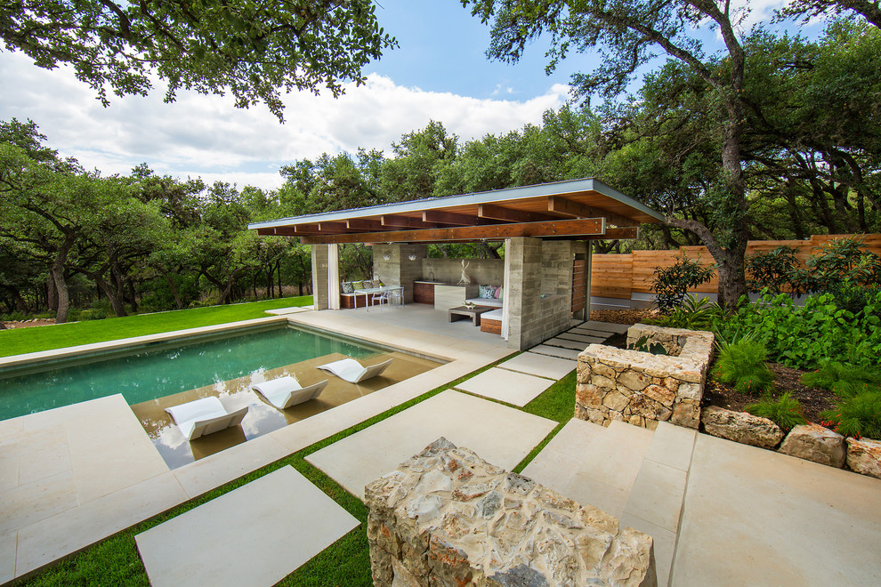 Large minimalist backyard stone and rectangular pool house photo in Austin