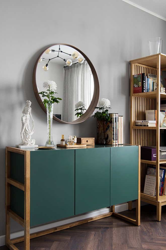 Esempio di un soggiorno design di medie dimensioni con libreria, pareti grigie, pavimento in laminato e pavimento marrone