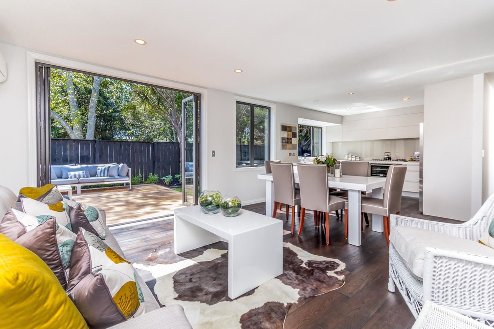 This is an example of a large contemporary kitchen/dining combo in Auckland with white walls, light hardwood floors and no fireplace.