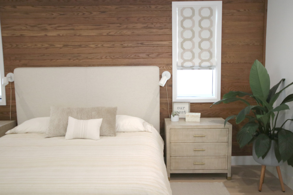 Modelo de dormitorio principal minimalista grande con paredes marrones, suelo de madera clara, suelo marrón y panelado