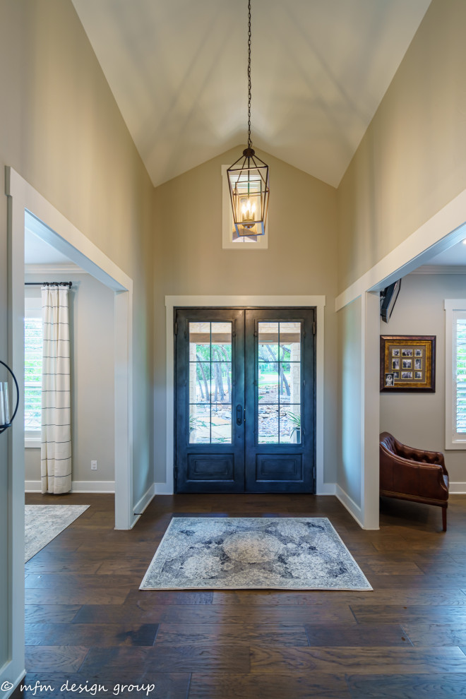 Mittelgroßes Modernes Foyer mit beiger Wandfarbe, dunklem Holzboden, Doppeltür, dunkler Holzhaustür, braunem Boden und gewölbter Decke in Austin
