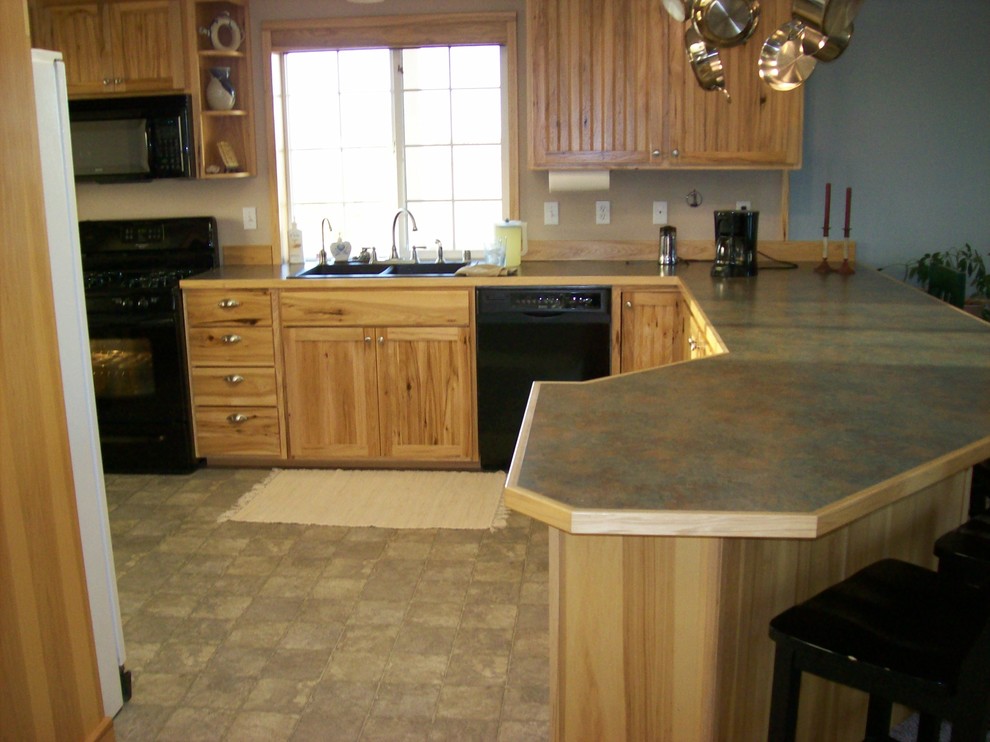 Inspiration for a mid-sized rustic u-shaped linoleum floor kitchen remodel with a double-bowl sink, beaded inset cabinets, light wood cabinets, laminate countertops, beige backsplash and black appliances