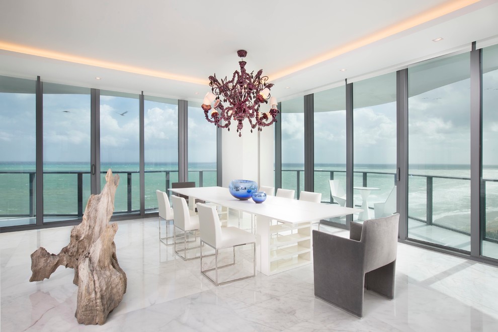 This is an example of a large contemporary open plan dining in Miami with white walls and marble floors.