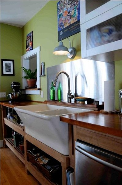 Eclectic kitchen photo in Burlington with a farmhouse sink, wood countertops and stainless steel appliances