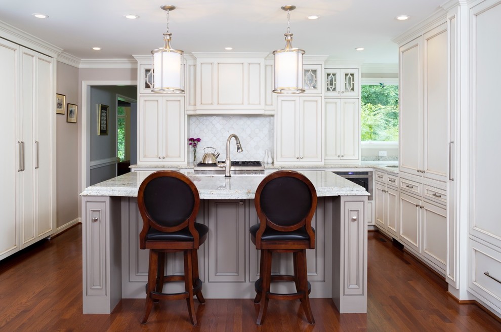 Mid-sized transitional l-shaped medium tone wood floor and brown floor eat-in kitchen photo in DC Metro with a farmhouse sink, raised-panel cabinets, white cabinets, quartzite countertops, white backsplash, ceramic backsplash, white appliances and an island