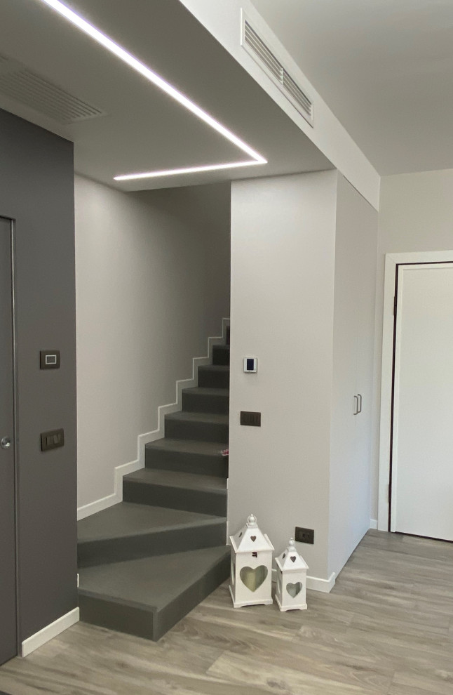 Moderne Treppe in L-Form mit Schiefer-Treppenstufen und Schiefer-Setzstufen in Mailand