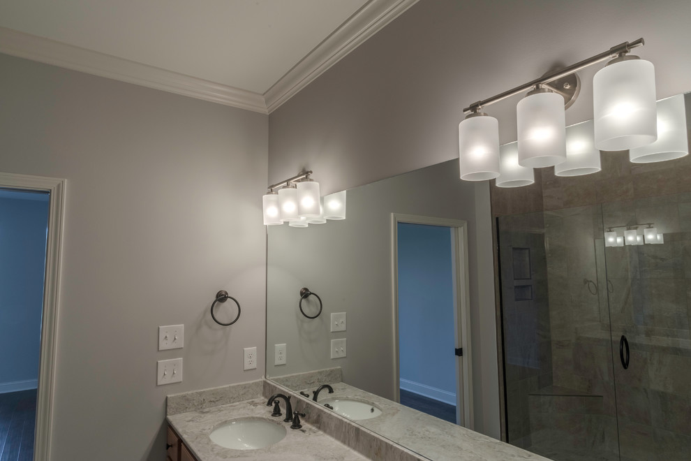 Example of a mid-sized transitional master beige tile and ceramic tile ceramic tile alcove shower design with shaker cabinets, medium tone wood cabinets, beige walls, an undermount sink and granite countertops