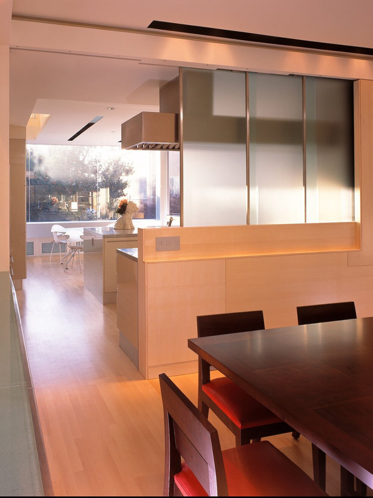 Cette image montre une salle à manger minimaliste avec un mur beige, parquet clair et un sol beige.