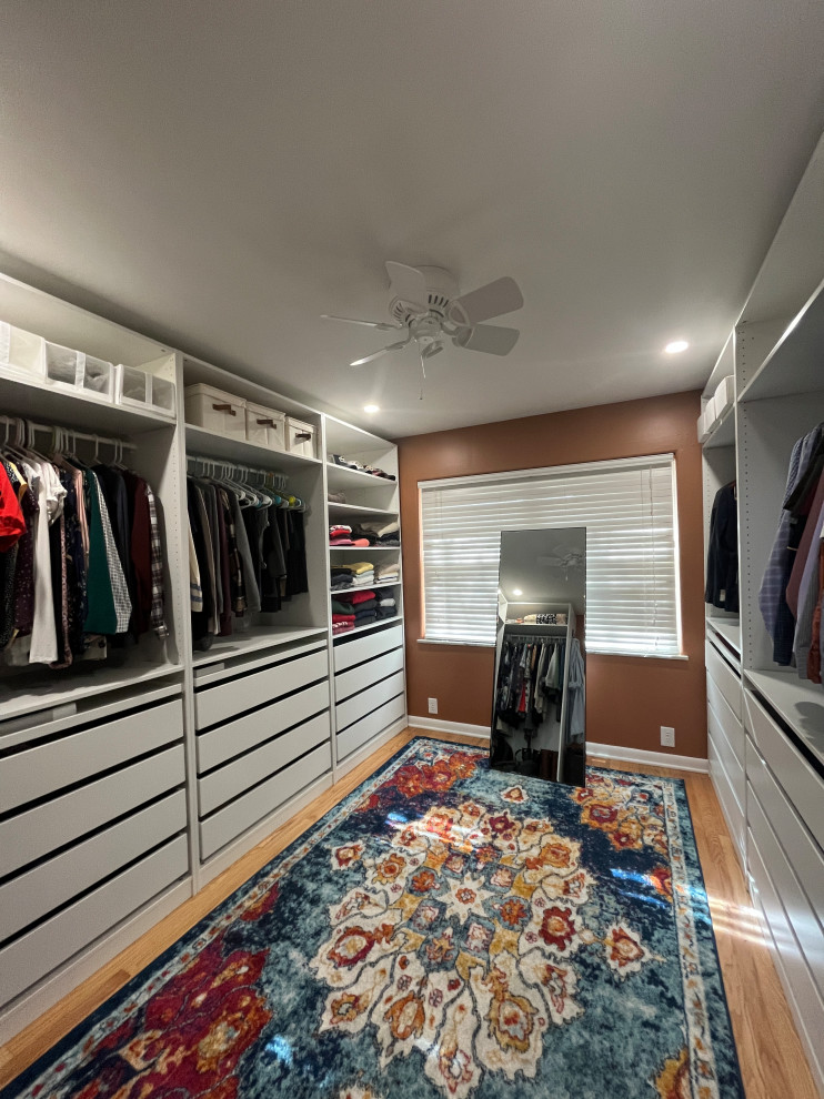 Idéer för att renovera ett mycket stort funkis walk-in-closet, med vita skåp, ljust trägolv och beiget golv