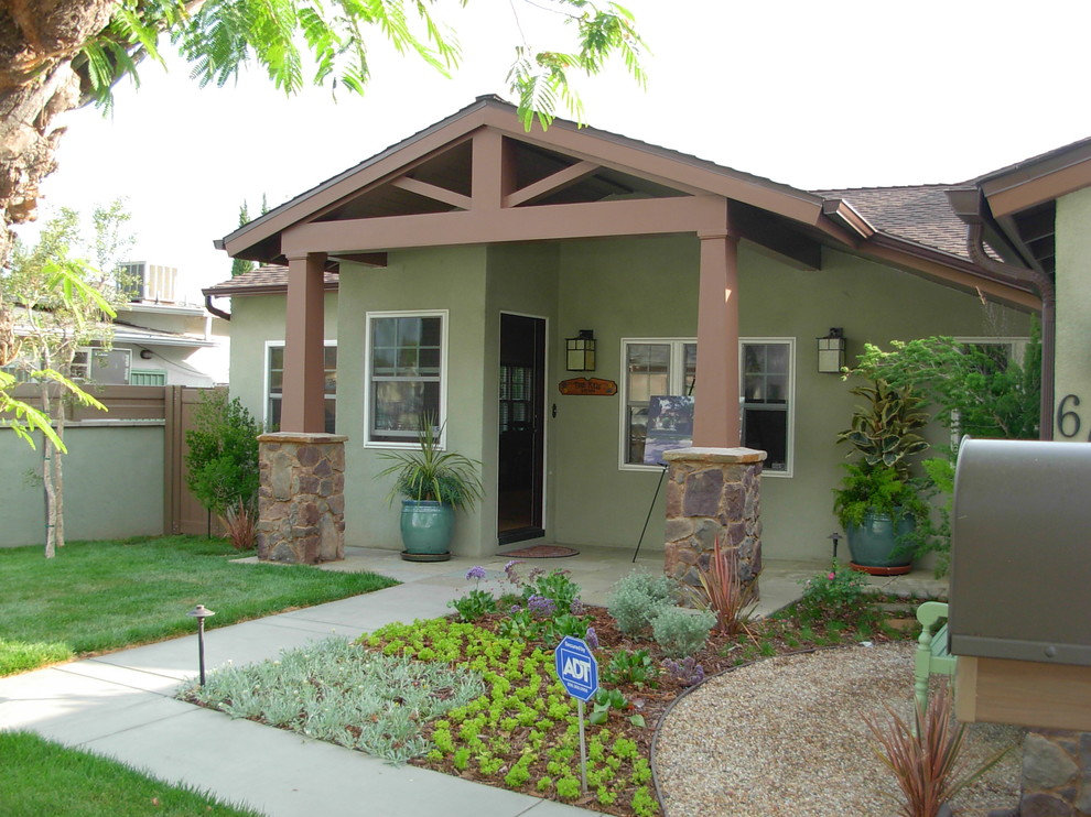 This is an example of a mid-sized arts and crafts one-storey stucco green house exterior in Los Angeles with a gable roof and a tile roof.