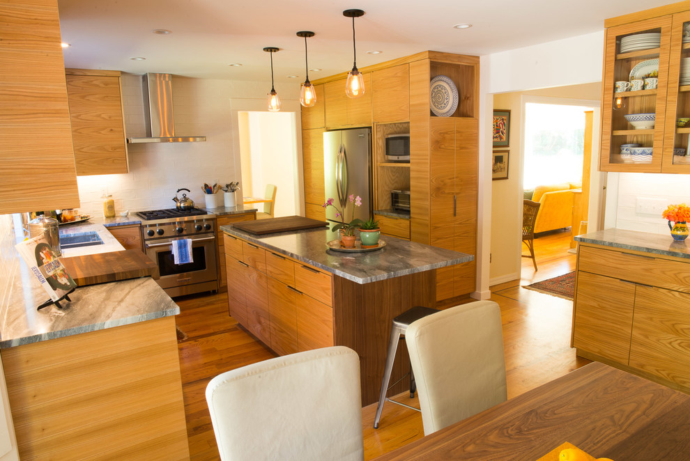 Mid-sized transitional u-shaped medium tone wood floor eat-in kitchen photo with an undermount sink, flat-panel cabinets, medium tone wood cabinets, quartzite countertops, white backsplash, ceramic backsplash, stainless steel appliances and an island