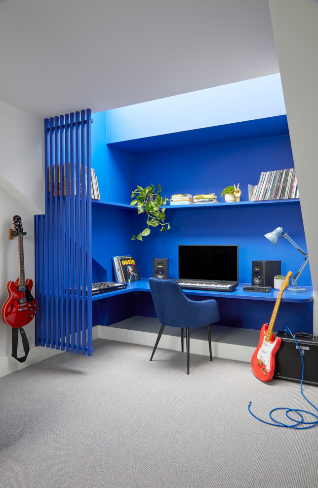 Idee per un grande studio contemporaneo con pareti blu, moquette, scrivania incassata e pavimento grigio