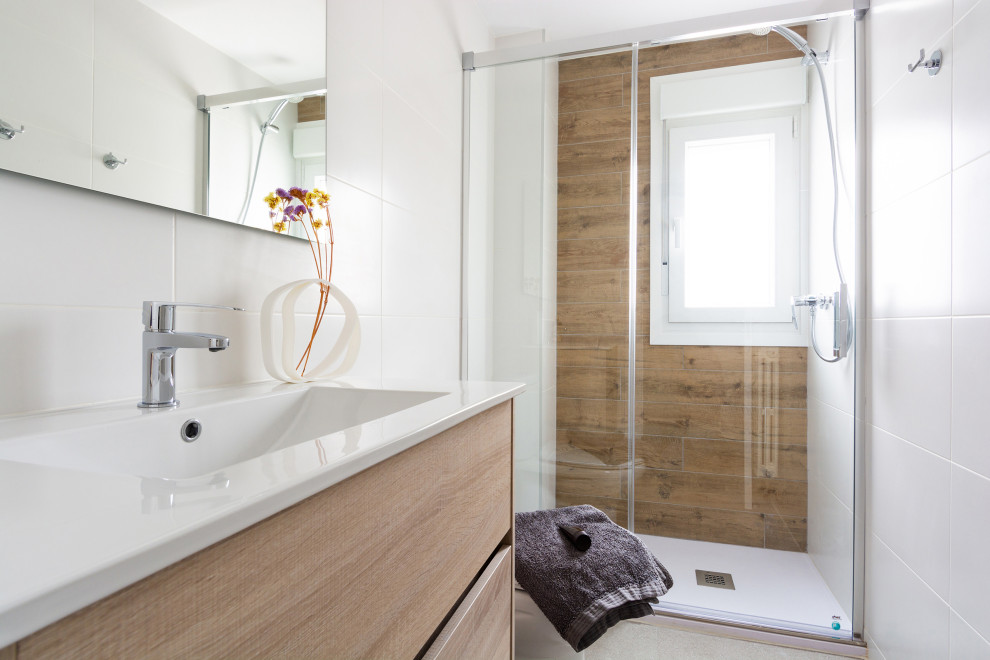 Idéer för att renovera ett mellanstort nordiskt en-suite badrum, med möbel-liknande, skåp i ljust trä, en kantlös dusch, en toalettstol med hel cisternkåpa, grå kakel, vita väggar, klinkergolv i porslin, grått golv och dusch med skjutdörr