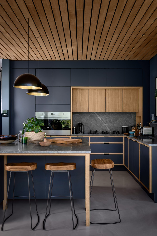 Immagine di un'ampia cucina moderna con pavimento in cemento, pavimento grigio e soffitto in legno