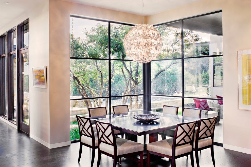 This is an example of a contemporary dining room in Austin with white walls and dark hardwood floors.