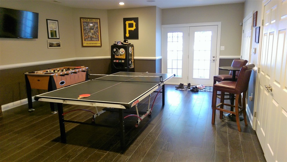 This is an example of a large traditional walk-out basement in Baltimore with multi-coloured walls, medium hardwood floors and beige floor.