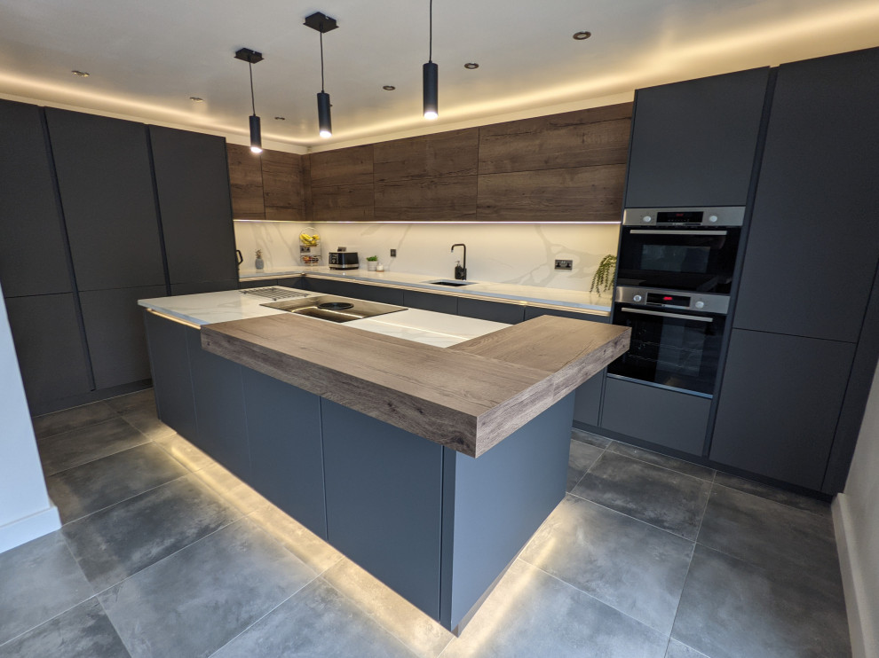 Design ideas for a medium sized contemporary cream and black enclosed kitchen in Other with a built-in sink, all styles of cabinet, black cabinets, quartz worktops, white splashback, black appliances, porcelain flooring, an island, grey floors, white worktops, all types of ceiling and feature lighting.