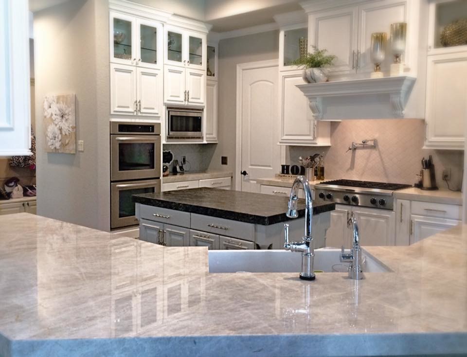 Mid-sized transitional u-shaped slate floor eat-in kitchen photo in Houston with a farmhouse sink, raised-panel cabinets, white cabinets, quartzite countertops, gray backsplash, stainless steel appliances, an island and porcelain backsplash