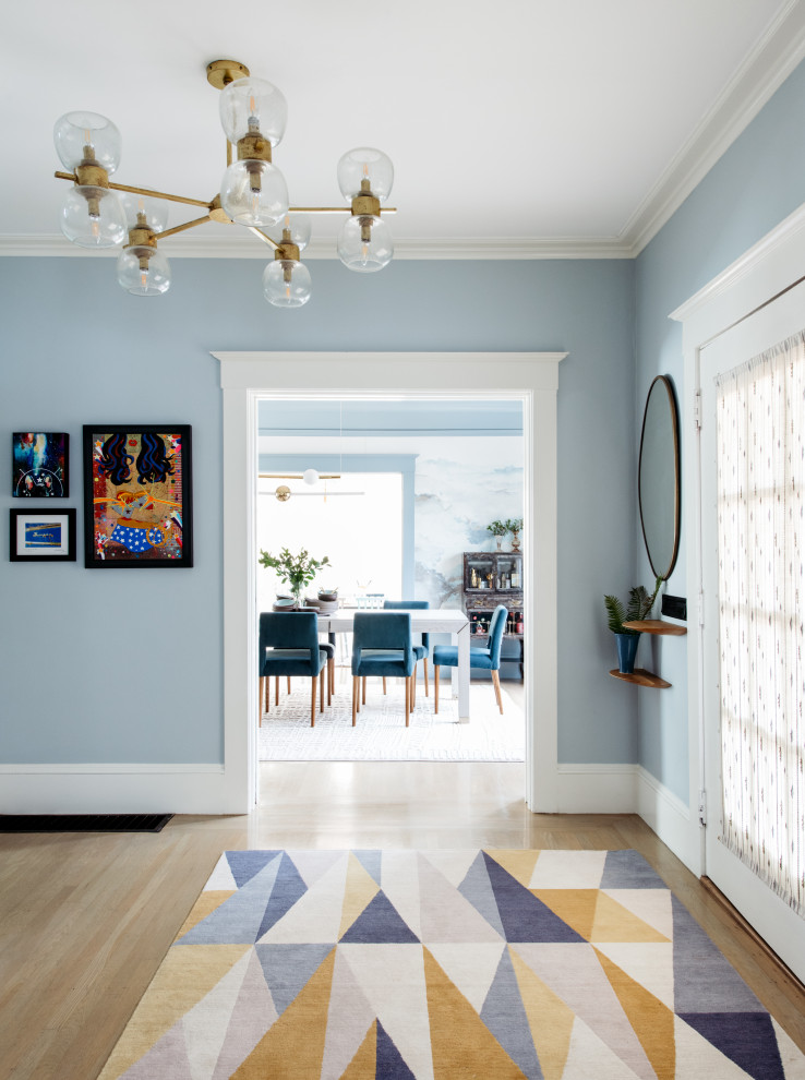 Réalisation d'une entrée tradition de taille moyenne avec un mur bleu, parquet clair, une porte simple, une porte blanche et un sol beige.