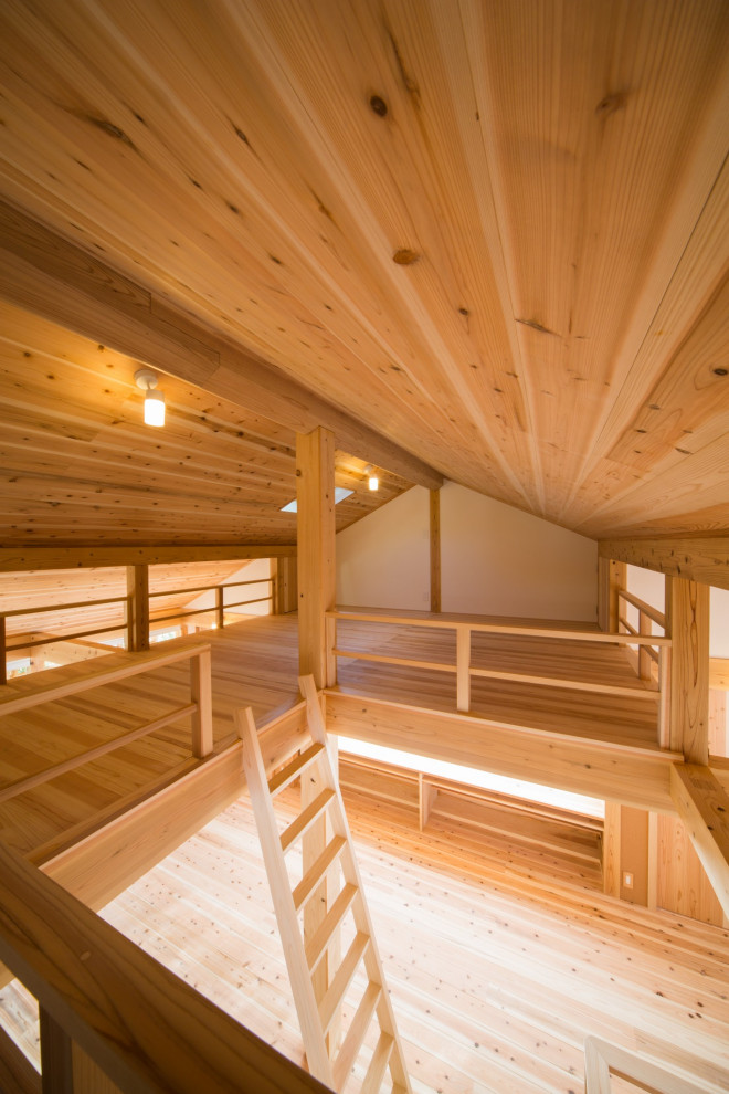 This is an example of a mid-sized asian loft-style bedroom in Kyoto with white walls and light hardwood floors.