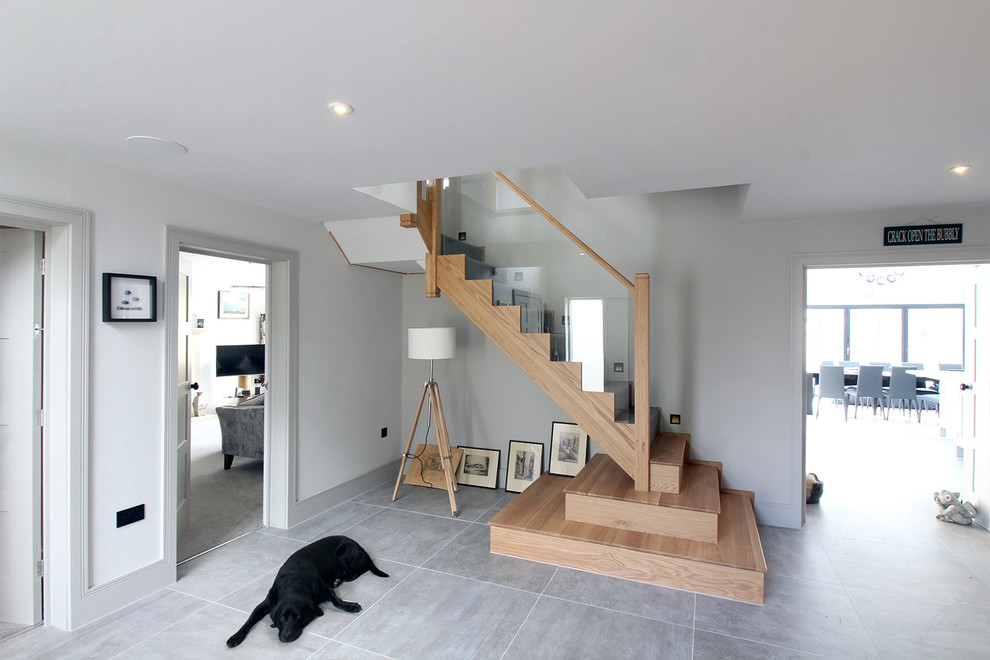 Design ideas for a mid-sized contemporary wood l-shaped staircase in West Midlands with wood risers and glass railing.
