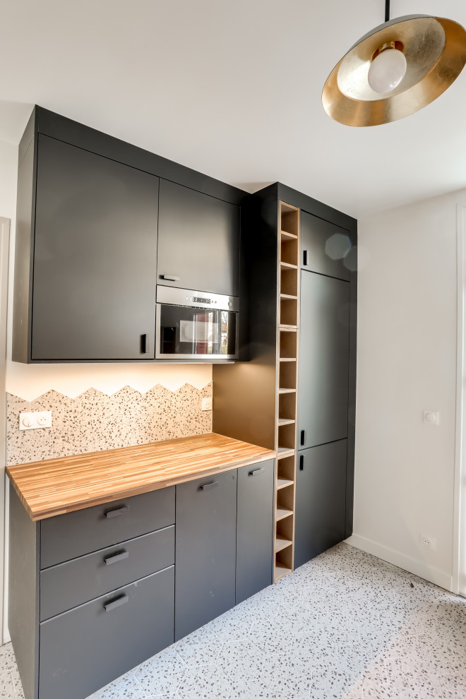 Mid-sized midcentury galley separate kitchen in Paris with a double-bowl sink, flat-panel cabinets, black cabinets, concrete benchtops, multi-coloured splashback, porcelain splashback, panelled appliances, ceramic floors, no island, multi-coloured floor and green benchtop.