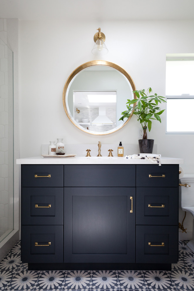 This is an example of a mid-sized beach style bathroom in Los Angeles with black cabinets, marble benchtops, multi-coloured tile, white walls, a console sink and shaker cabinets.