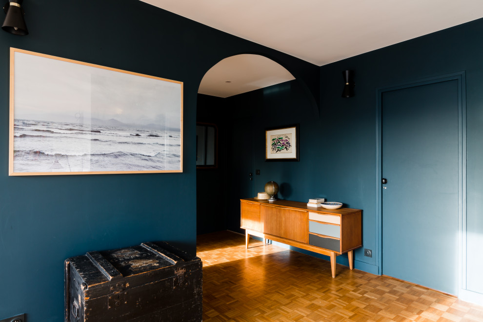 Ispirazione per una piccola porta d'ingresso moderna con pareti blu, una porta blu e pavimento marrone