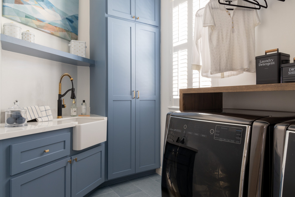 Ispirazione per una sala lavanderia moderna di medie dimensioni con lavello stile country, ante in stile shaker, ante blu, top in quarzo composito, pareti grigie, lavatrice e asciugatrice affiancate e top bianco